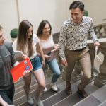 Grupa studentów z teczkami wchodzi do biblioteki