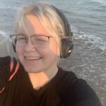 Wiktoria Nowak, studentka UASM na plaży w słuchawkach