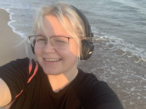 Wiktoria Nowak, studentka UASM na plaży w słuchawkach